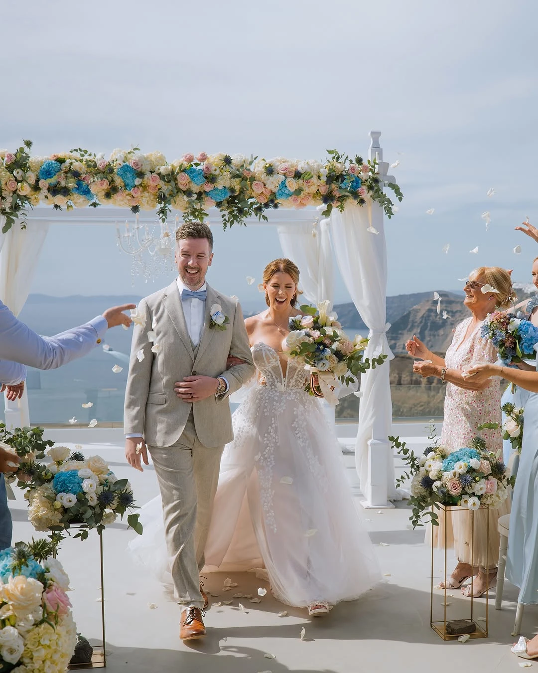 Bride and groom walking back down the aisle with petals being thrown around them.
